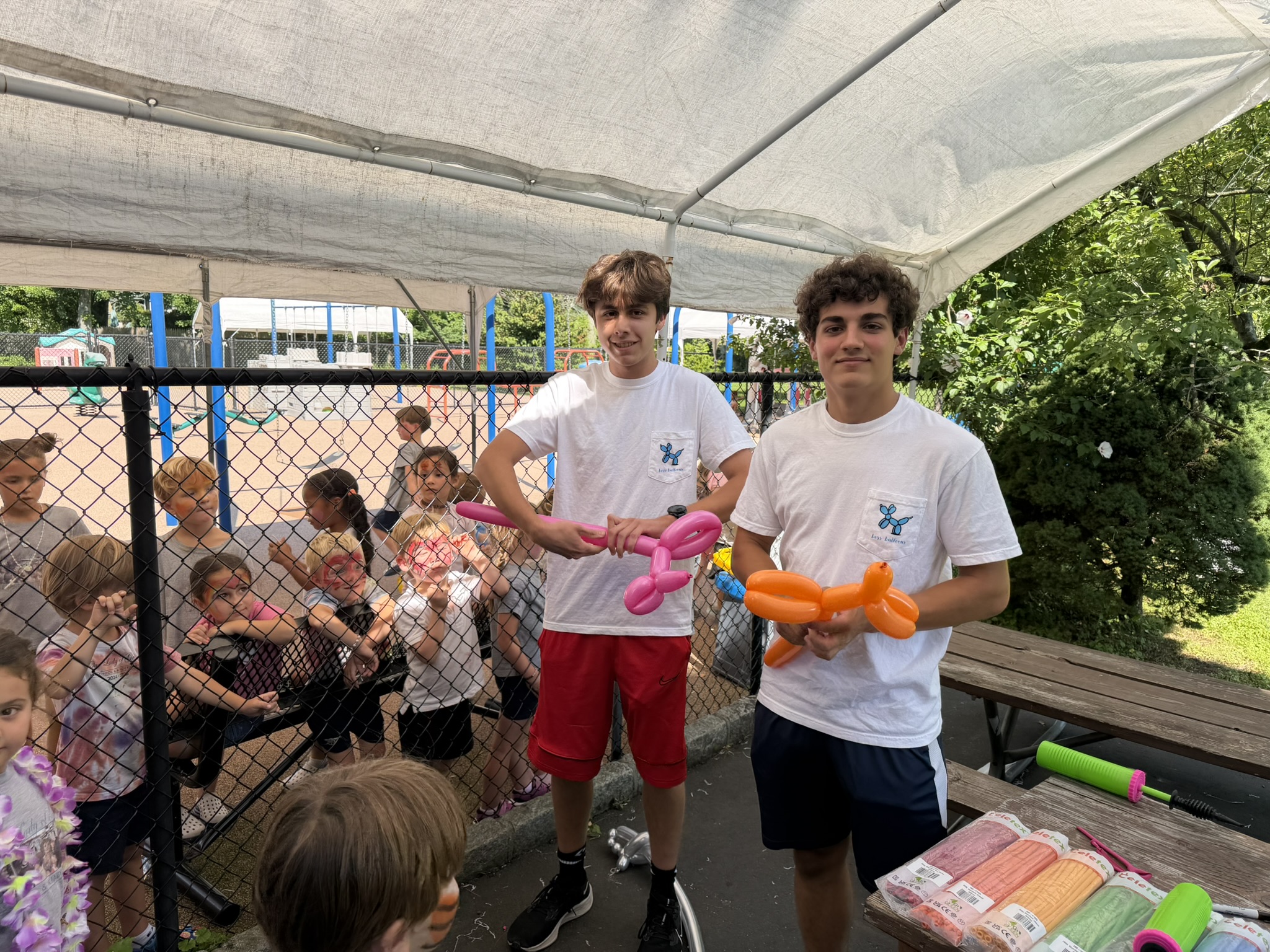 Two Boss Balloons artists making balloon animals at a children's party