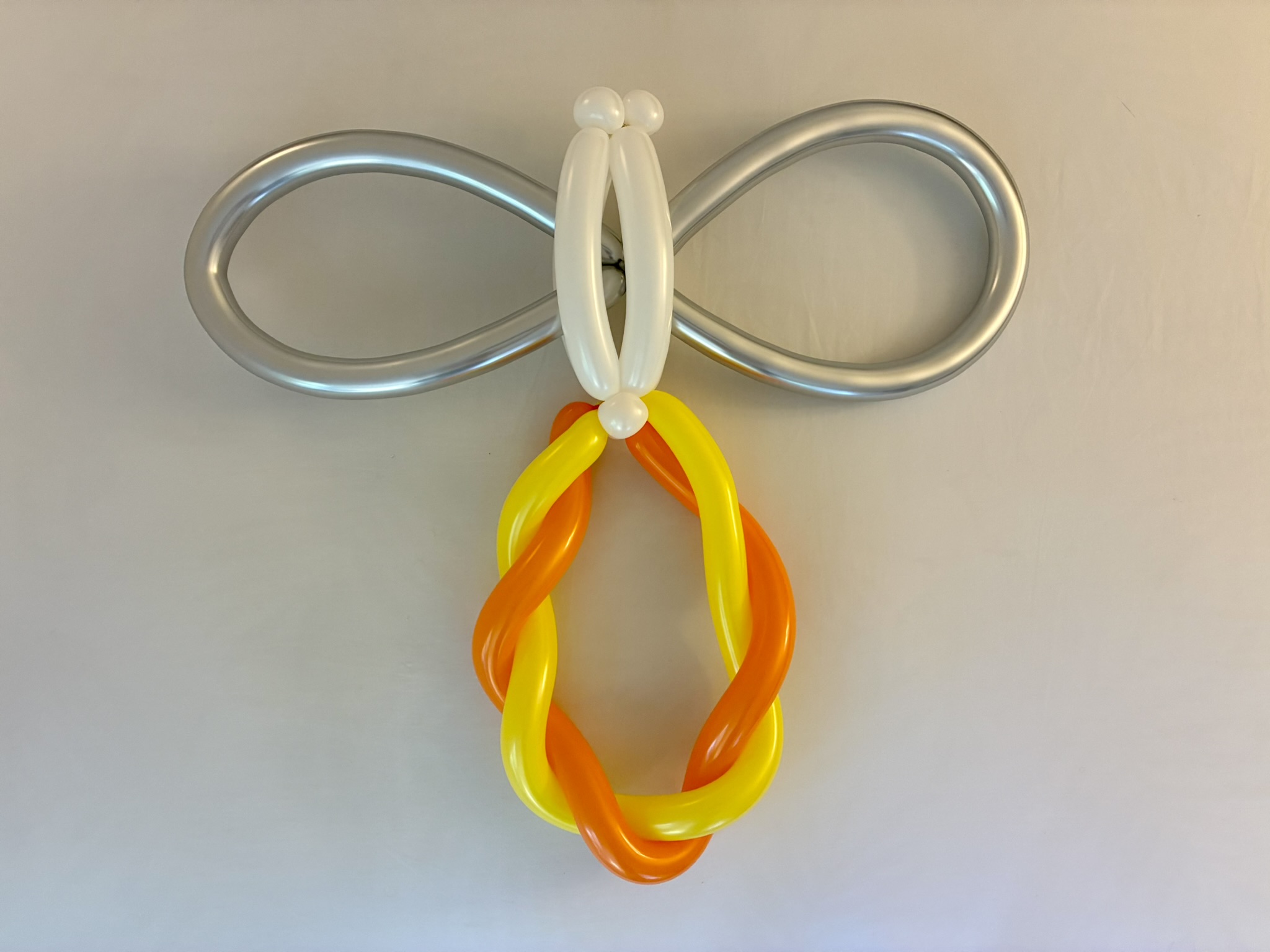 Silver, white, yellow, and orange balloon sculpture